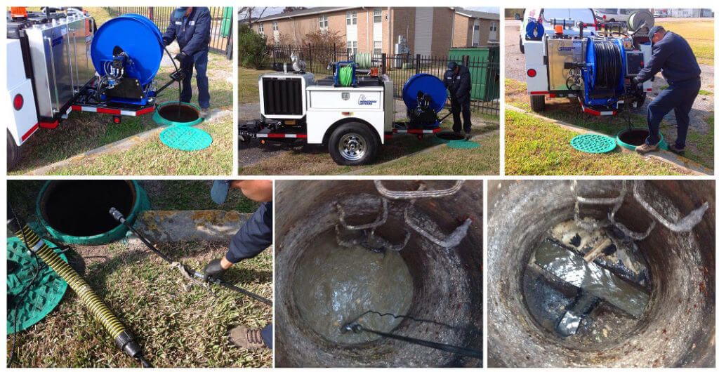 Worker at open manhole performing sewer jetting maintenance